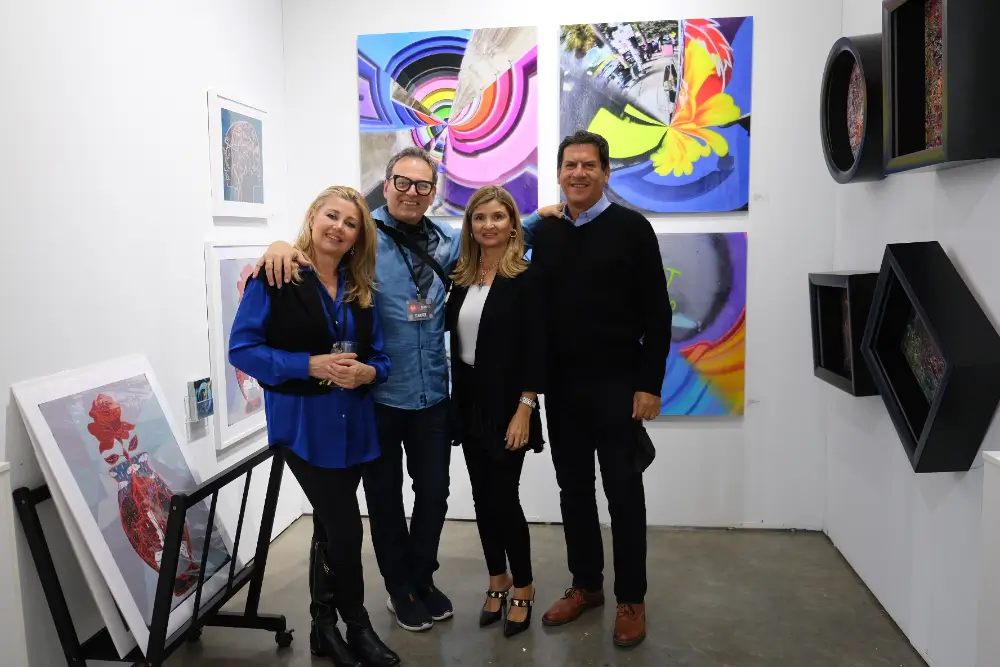 A group of people standing in front of some paintings.