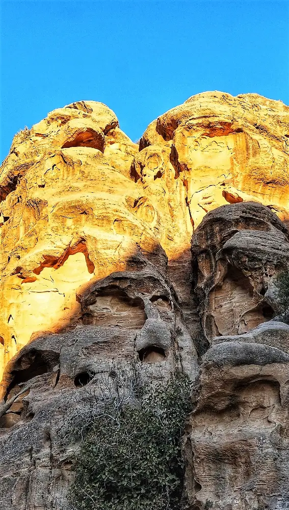 A rock formation with many faces on it.