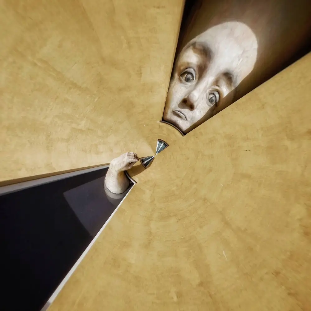 A person with their face in the middle of a wall.