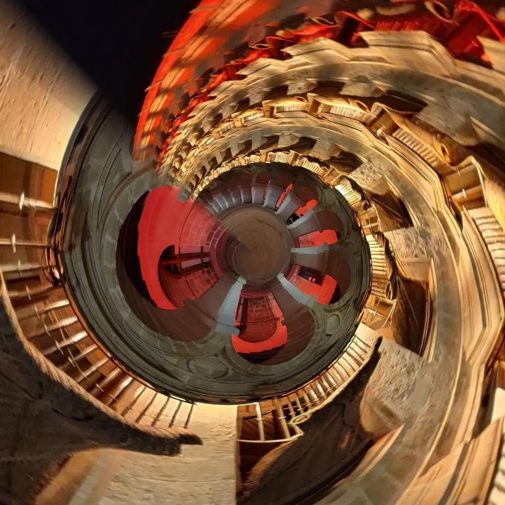 A spiral staircase with red and brown steps.