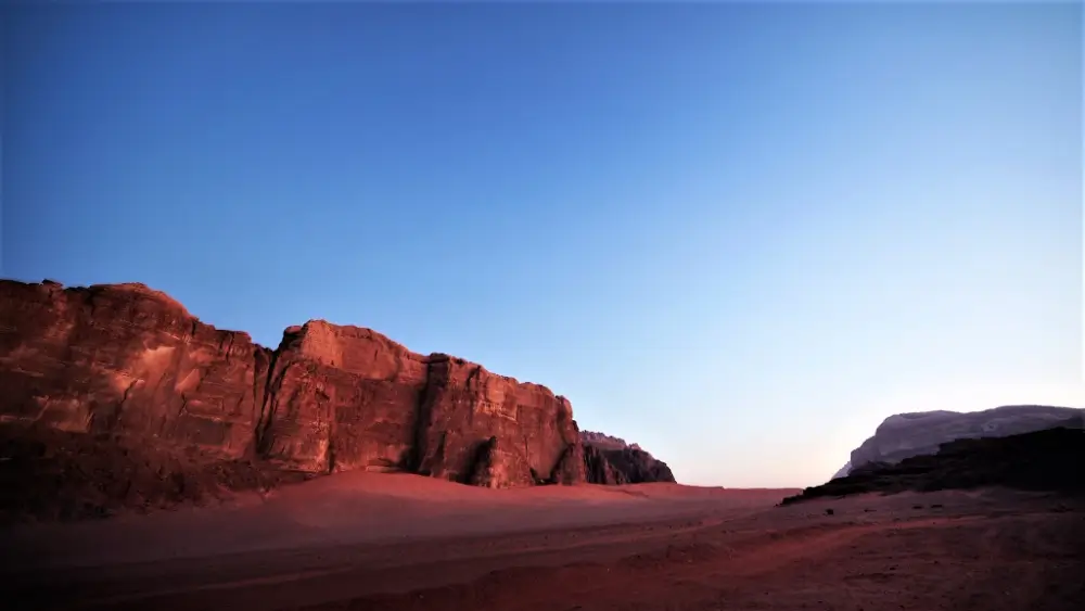 A desert landscape with mountains in the background.