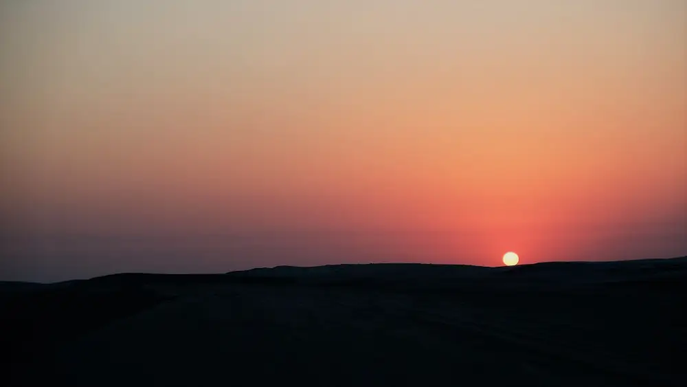 A sunset with the sun setting in the distance.