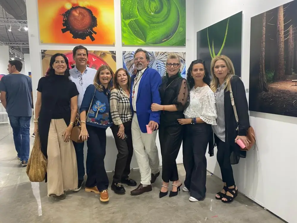 A group of people standing in front of some paintings.