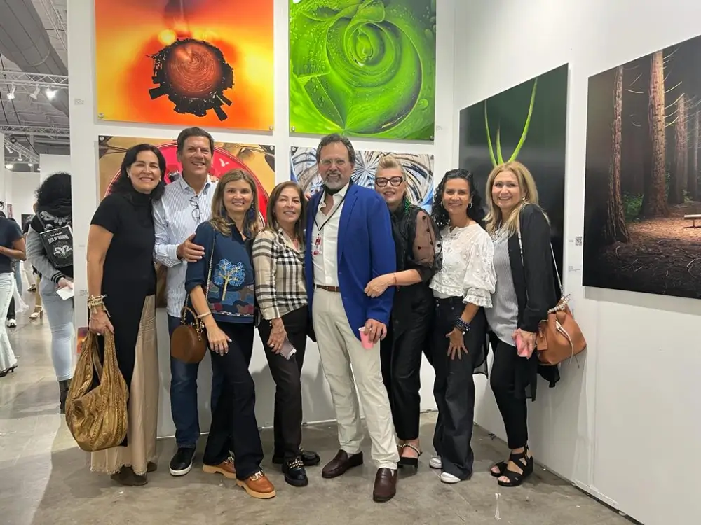 A group of people standing in front of some paintings.