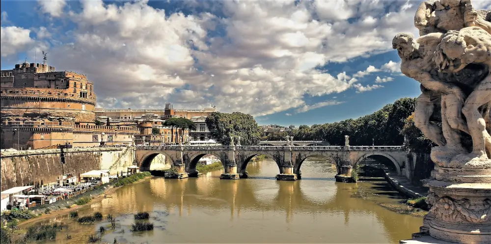 A bridge over water with clouds in the sky.