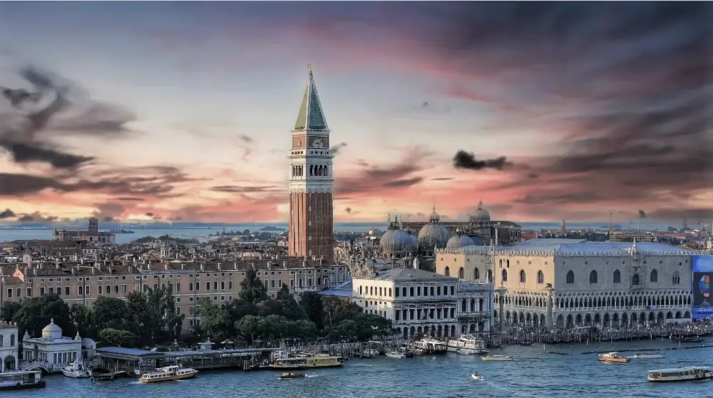 A large clock tower towering over the city of venice.