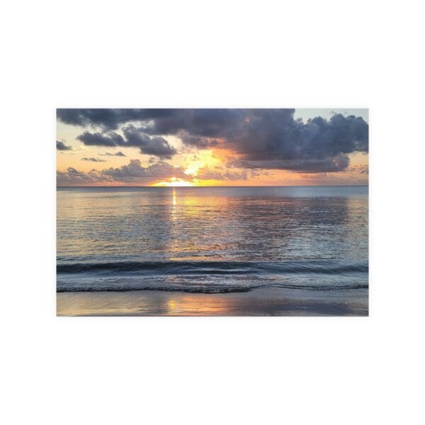 A sunset over the ocean with clouds in the sky.