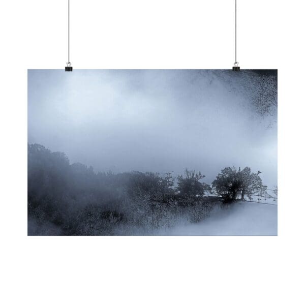 A hanging poster of trees and fog in the distance.