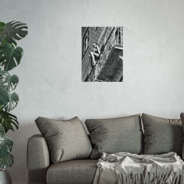 A couch and plant in a room with a painting on the wall.