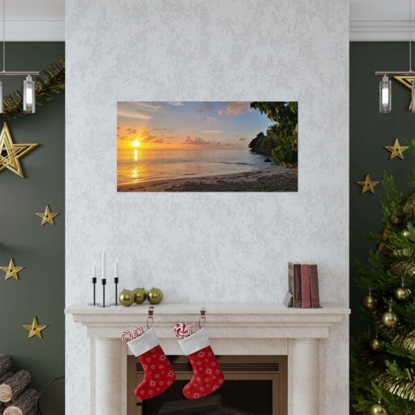 A fireplace with christmas stockings and a painting of the sun setting over the ocean.