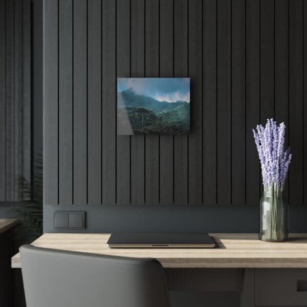 A desk with a laptop and vase of flowers