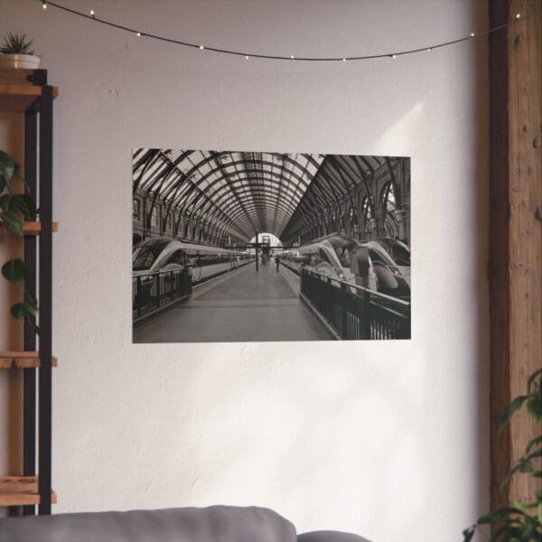 A black and white photo of an indoor train station.