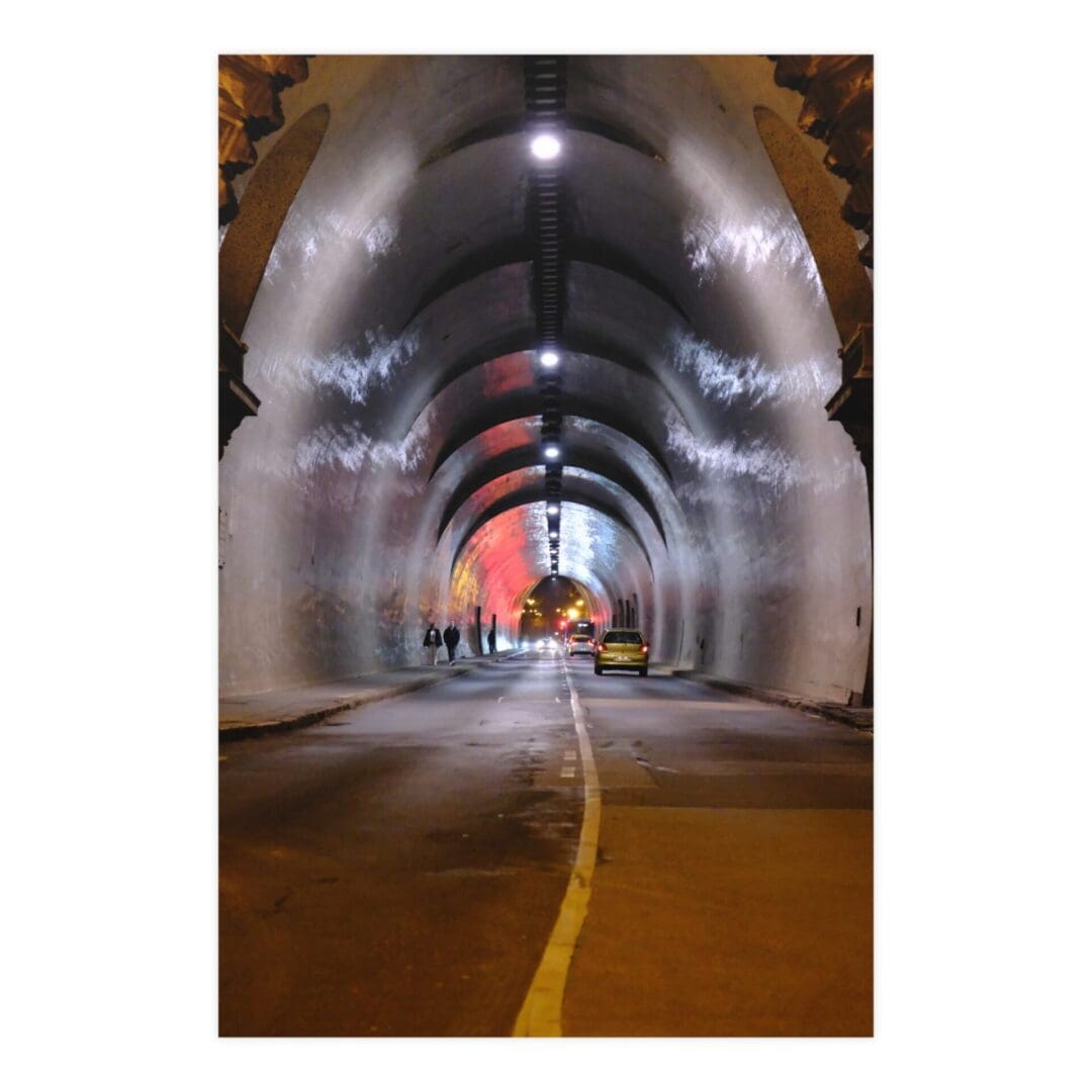 A tunnel with lights and cars on the side.