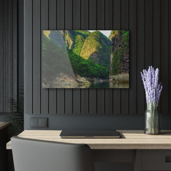 A painting of a green mountain in front of a black wall.