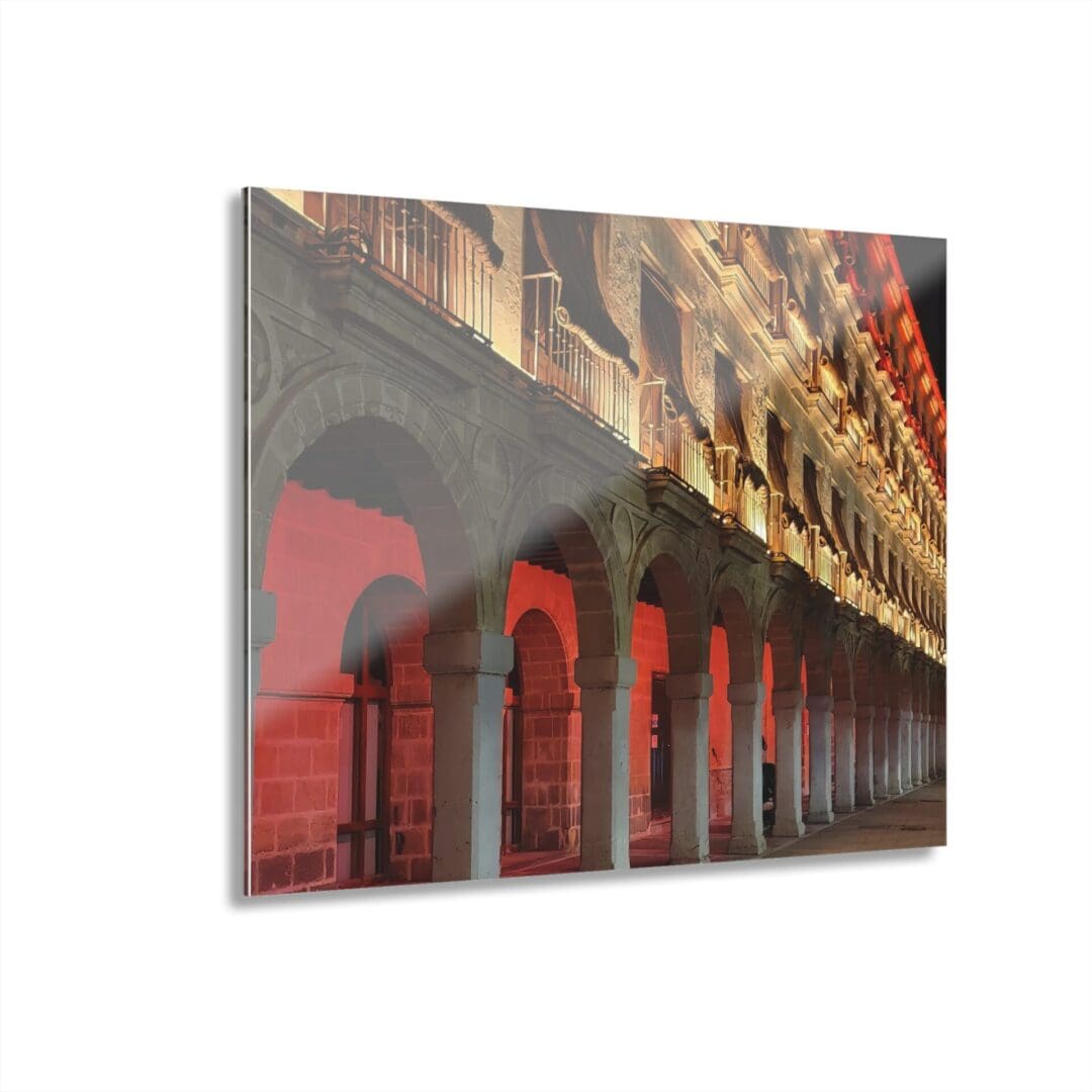 A red and white building with arches reflected in the mirror.