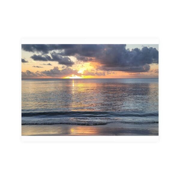 A sunset over the ocean with clouds in the sky.