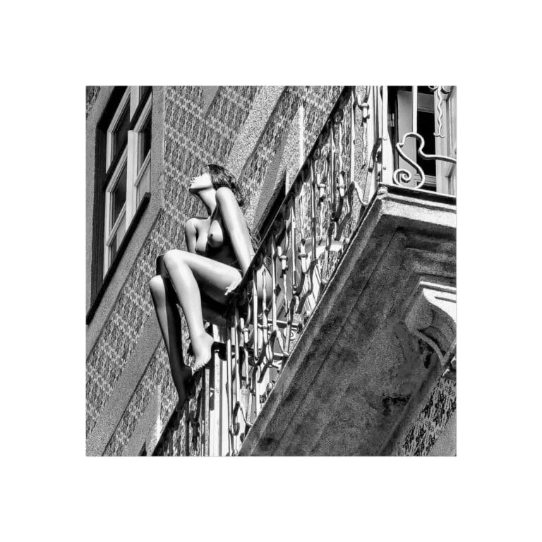 A woman sitting on the side of a building.