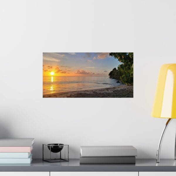 A sunset over the ocean with a yellow lamp on the wall.